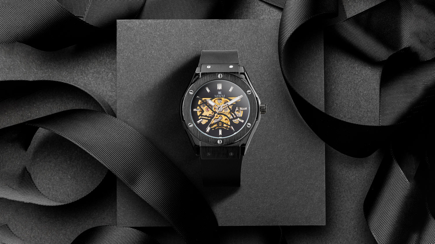 Noir Mars is a black watch with gold automatic movement on a black background - Representing Mark W. Morrison's vision of great watches at fair prices, inspired by the father of the modern chronometer and Audemars Piguet